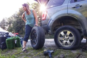 Woman with blown tire on the side of the road