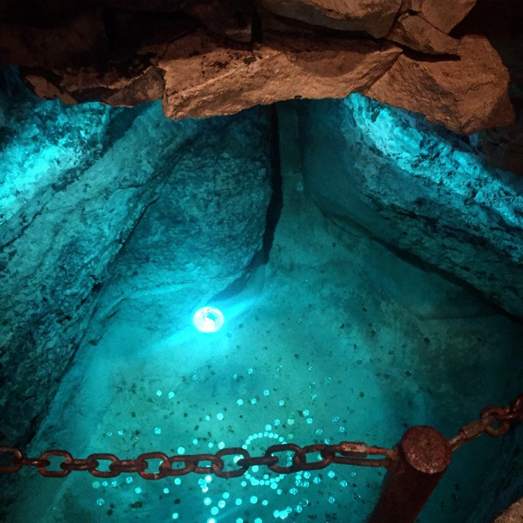 wishing well in spelunking cave Spelunking with Kids in Tyendinaga Caverns and Caves #ontariotravel #thingstodowithkidsinontario #tyendinaganativereserve #cavernsandcaves #spelunking #spelunkingwithkids #coolplacesinontario #familytravelblogger #bestfamilytravelblogger #firstnationsreserve 