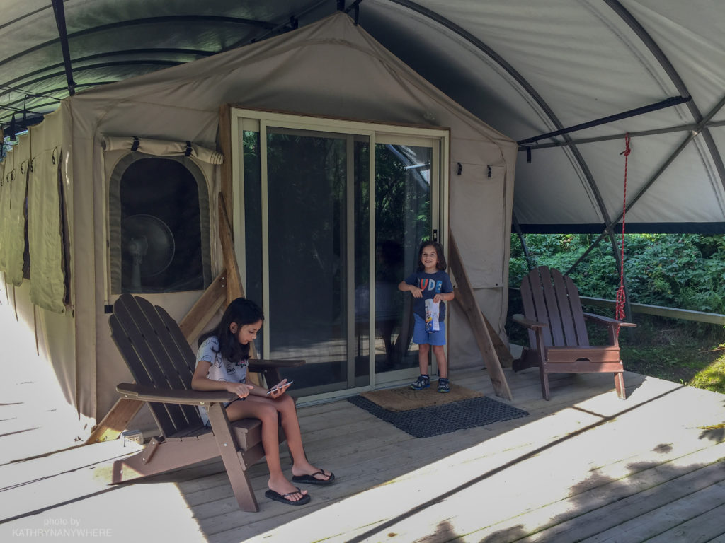 Luxury Family Glamping Ontario, children on front verandah #norfolkcounty #glamplife #kidswhoglamp #torontokids #torontofamily #wildernesssuite #campingpod #glampingontario