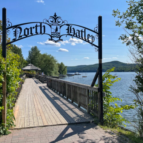 North Hatley sign beside lake in front of a walkway