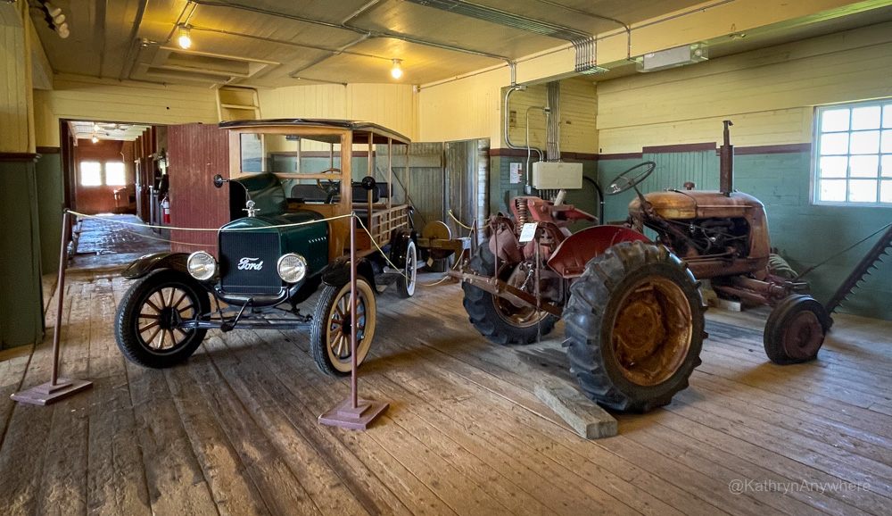 Interior barn, antique Ford vehicle and a tractor